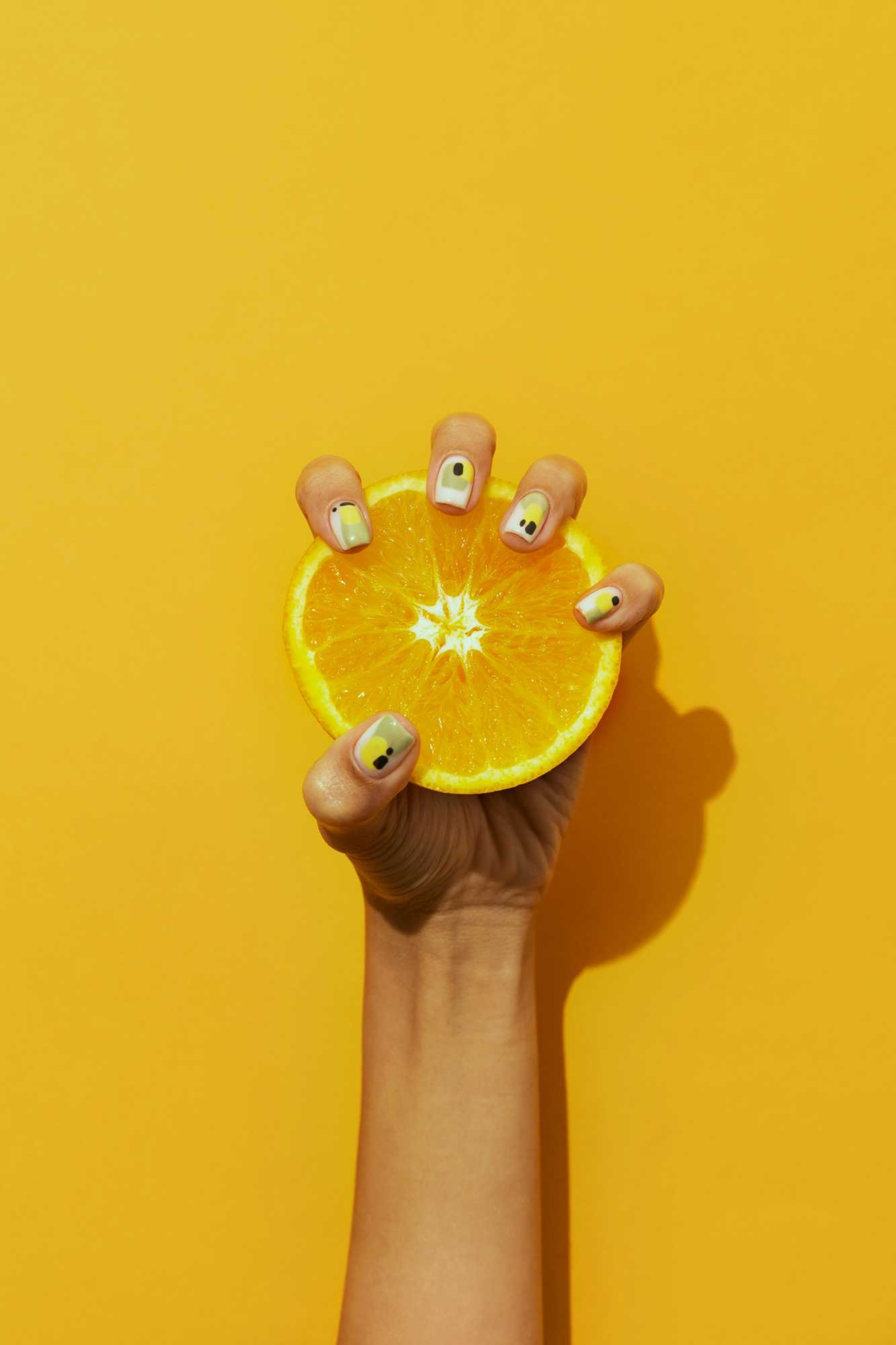 woman-showing-her-nail-art-fingernails-with-citrus