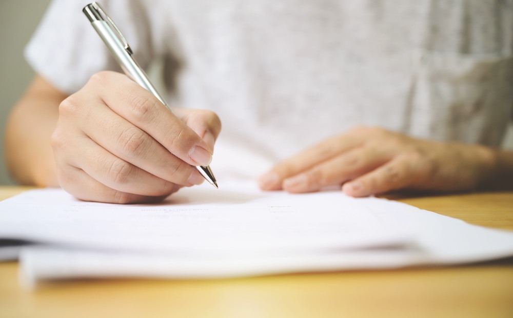 hand-man-signing-signature-filling-application-form-document