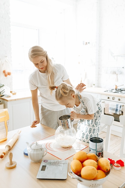 mom-daughter-cooking-cookies-together-kitchen_221811-1