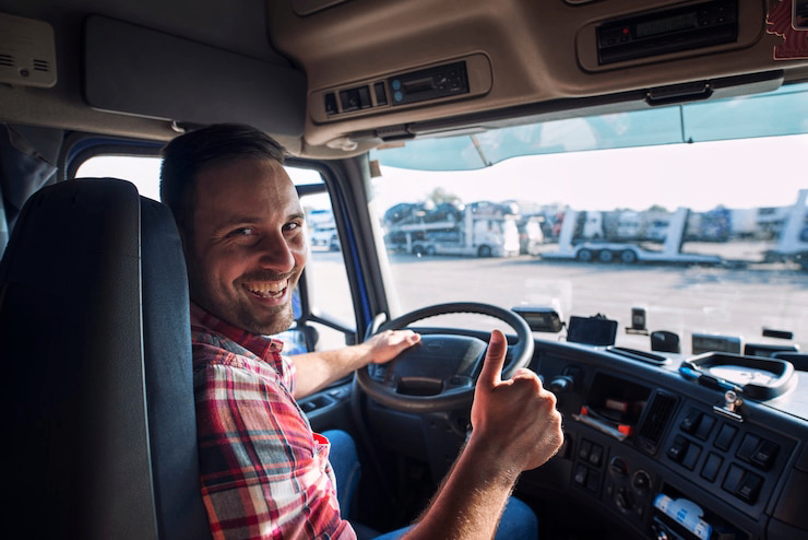portrait-of-truck-driver-sitting-in-his-truck-holding-thumbs-up_342744-13401