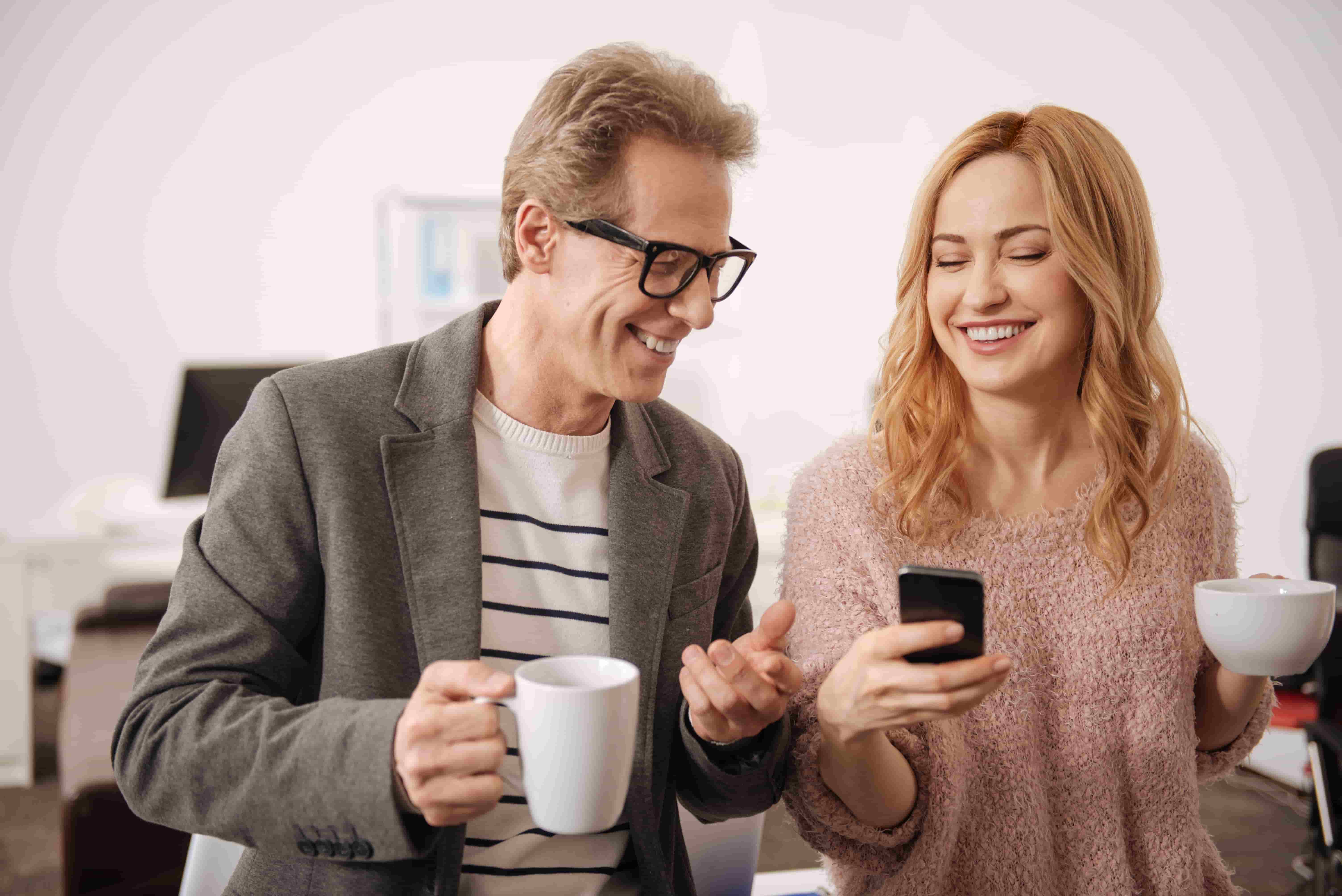 smiling-happy-amused-colleagues-standing-business-center-expressing-positivity-while-enjoying-conversation-drinking-tea_1