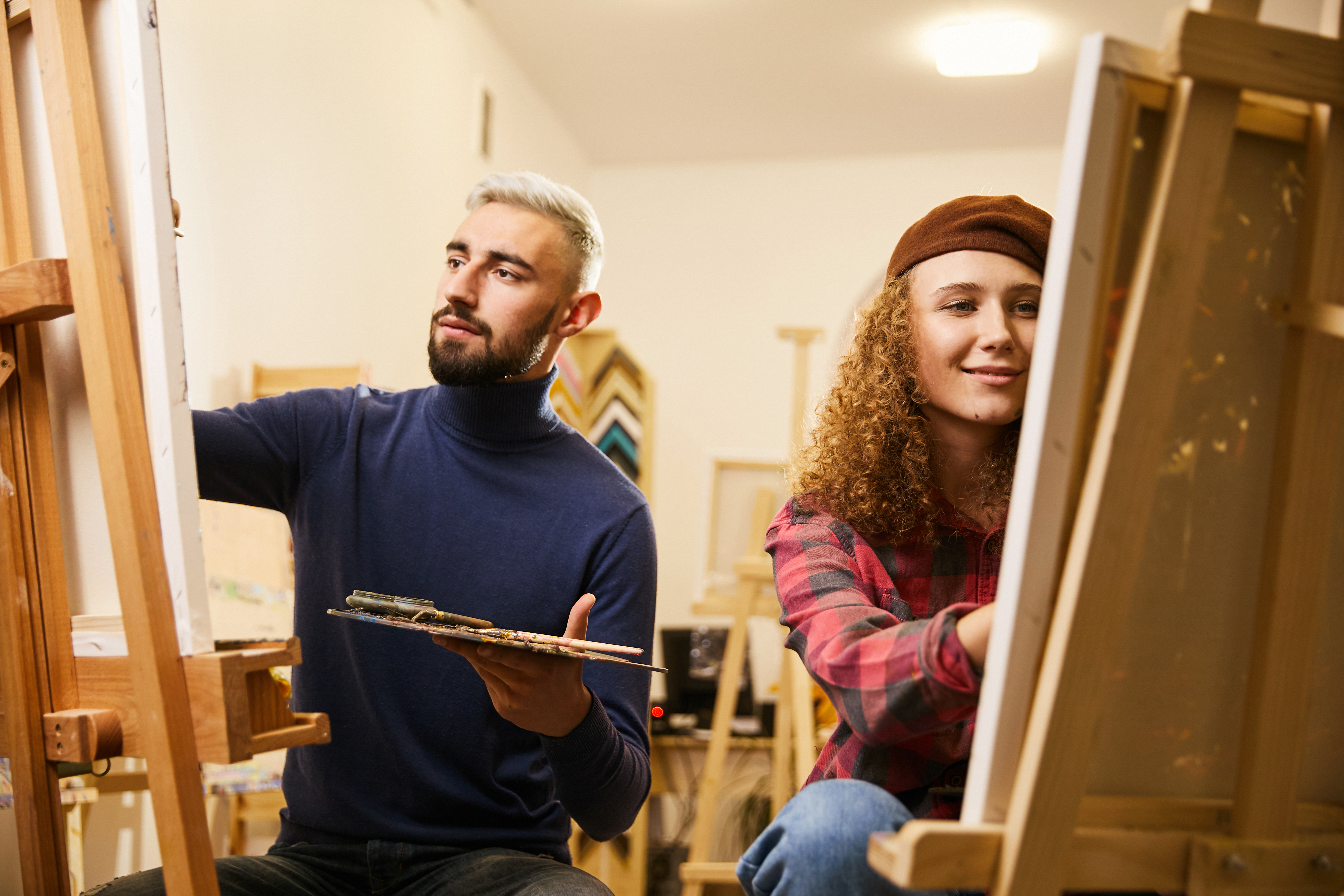 man-woman-draw-paintings-easels
