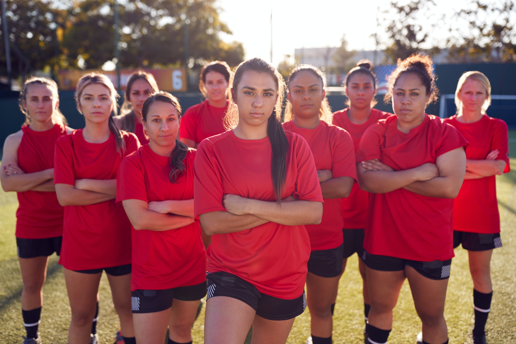 portrait-of-womens-football-team-training-for-soccer-match-on-outdoor-astro-turf-pitch