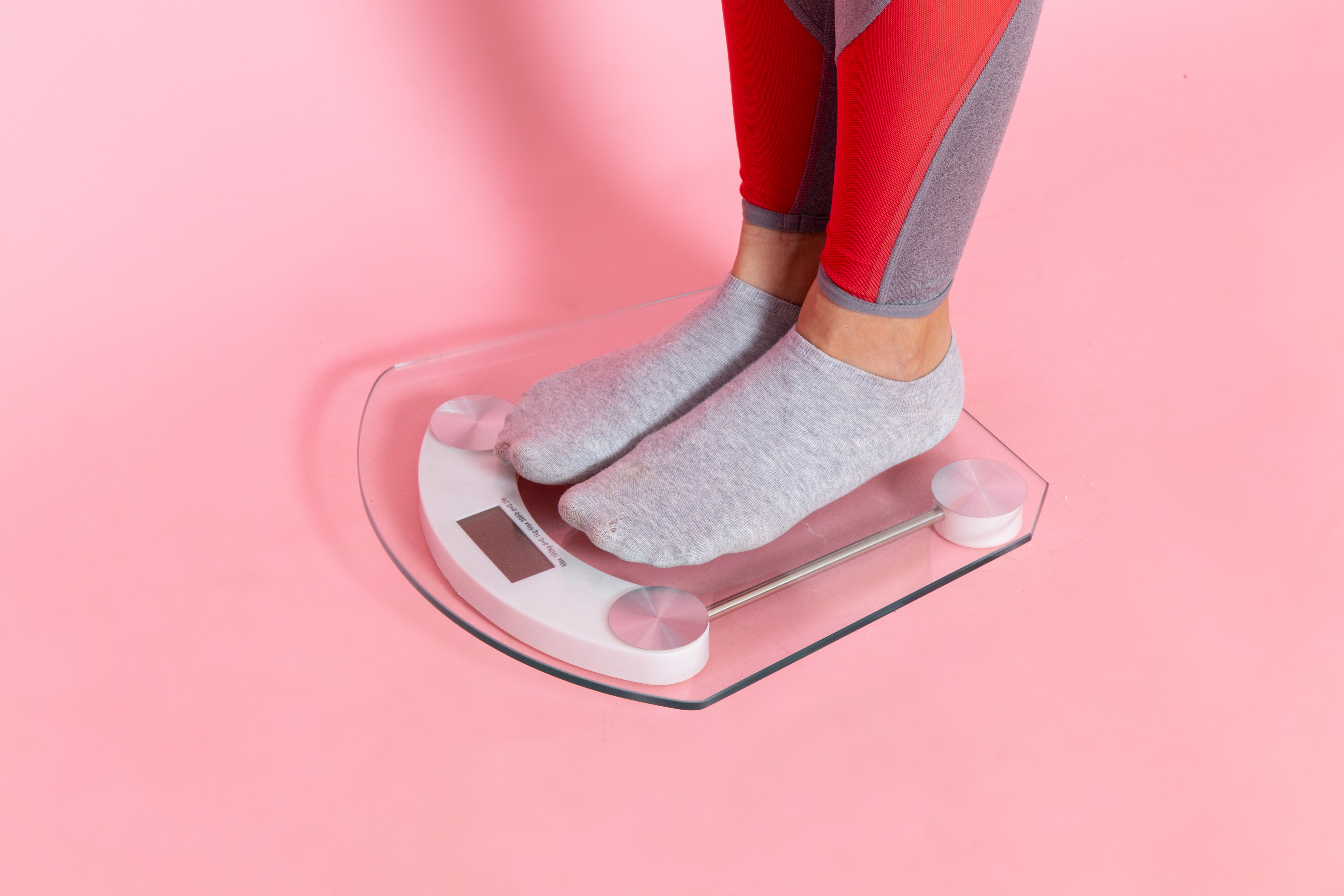 front-view-young-female-measuring-her-weight-pink-wall-exercise-sport-workout-athlete-waist-beauty