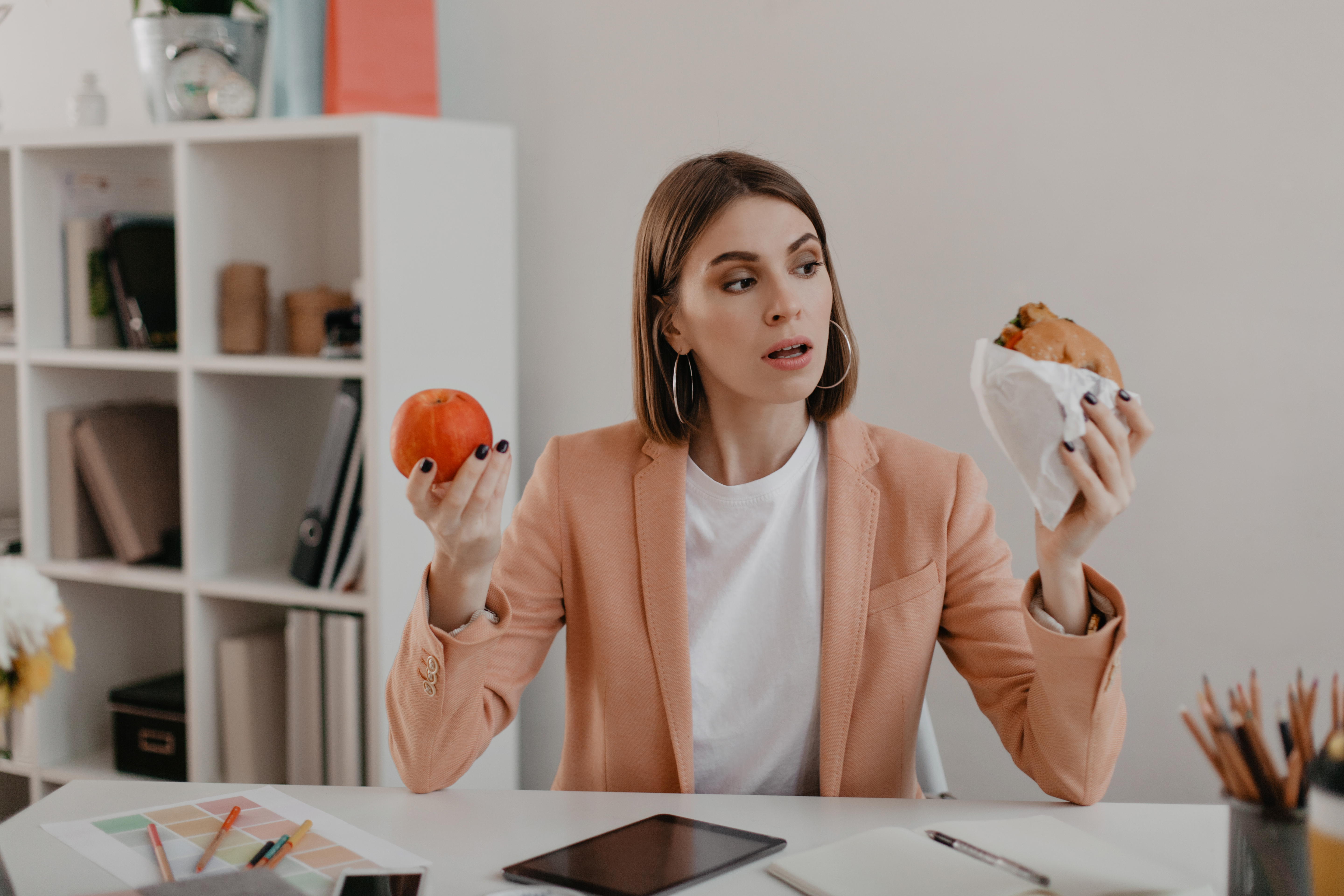 picture-business-woman-pink-jacket-sitting-workplace-woman-choose-tasty-burger-wholesome-apple