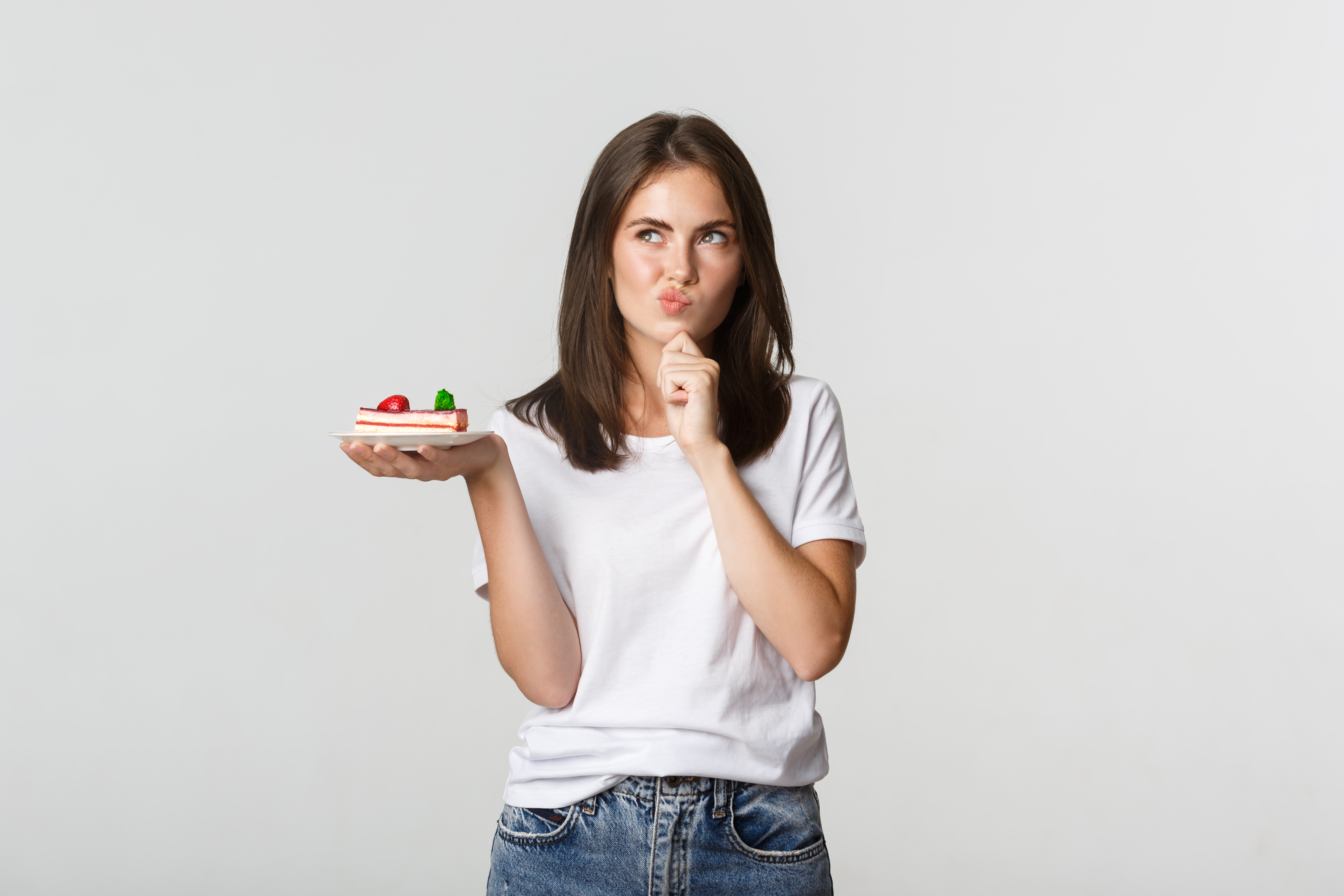 thoughtful-smiling-pretty-girl-pondering-while-holding-piece-cake-white