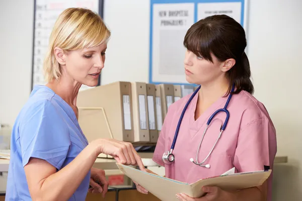 depositphotos_24645989-stock-photo-two-nurses-discussing-patient-notes