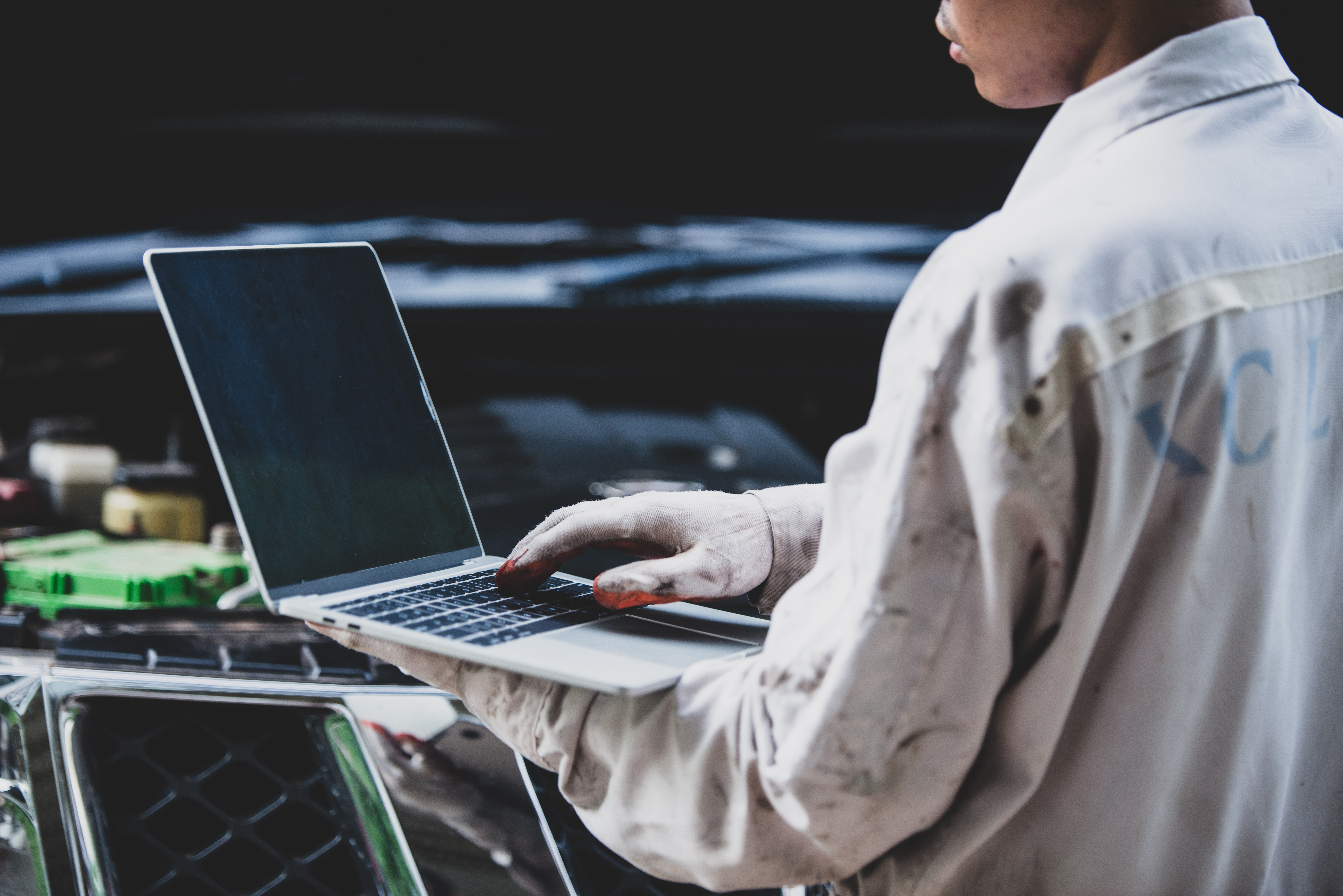 car-repairman-wearing-white-uniform-standing-holding-wrench-that-is-essential-tool-mechanic-with-laptop-checking-engine