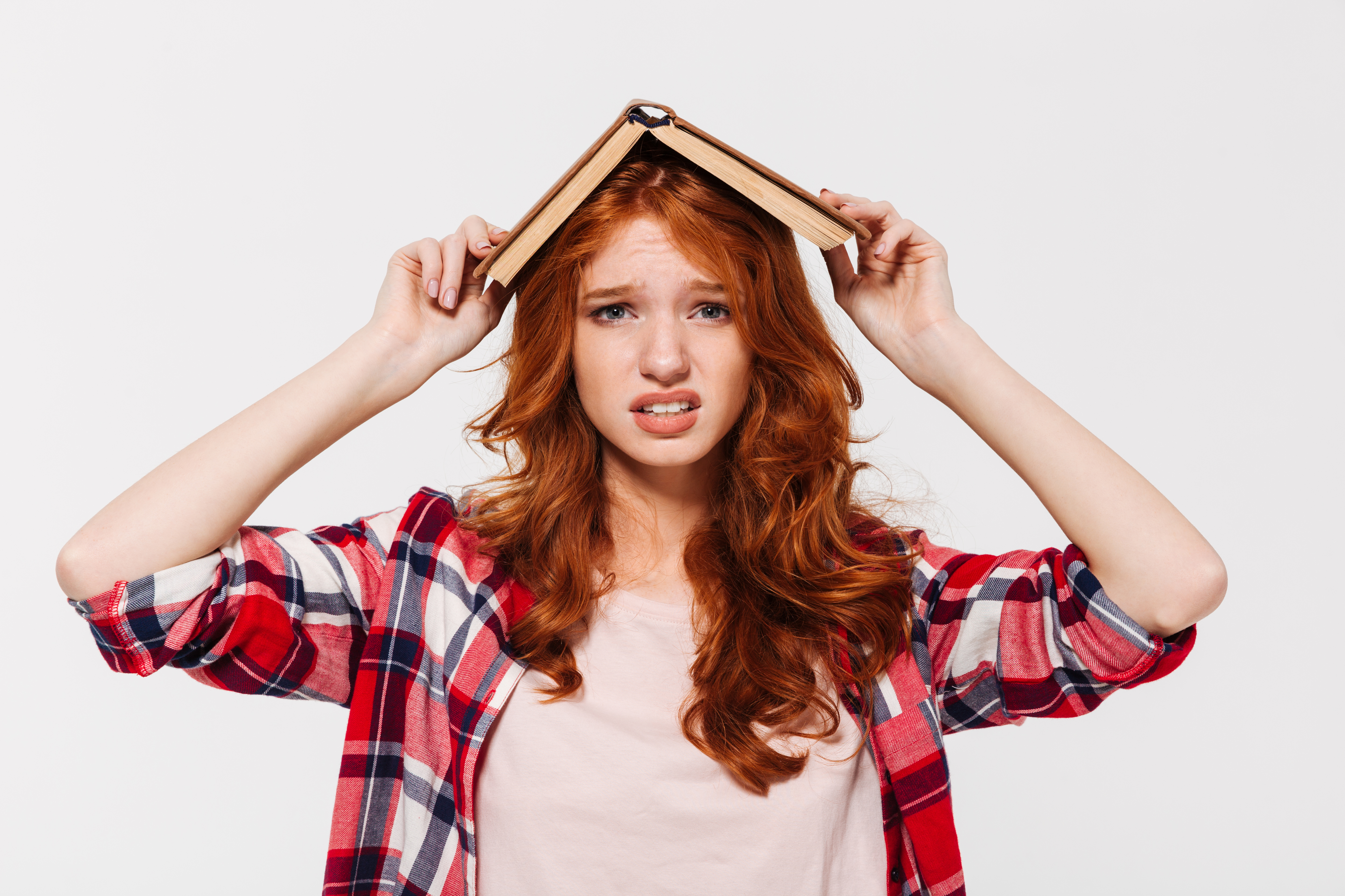 confused-ginger-woman-shirt-holding-book-her-head