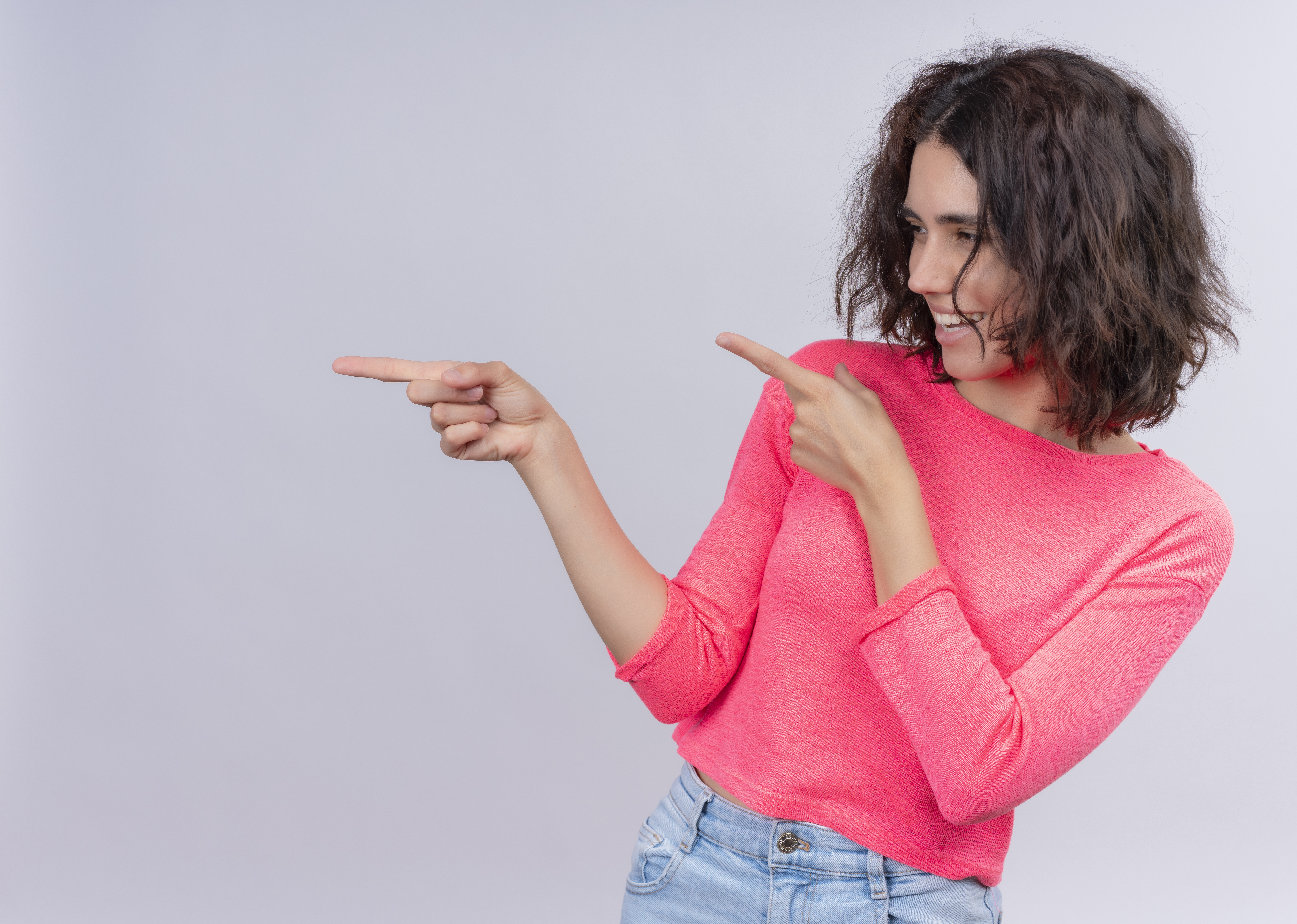 laughing-young-beautiful-woman-pointing-left-side-isolated-white-wall-with-copy-space