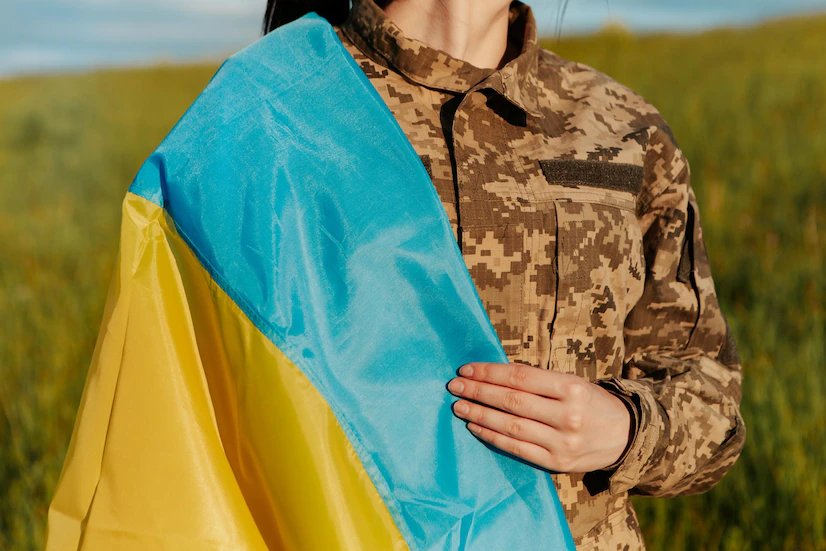 female-soldier-dressed-in-military-uniform-wrapped-in-ukrainian-flag_267895-3851.jpg