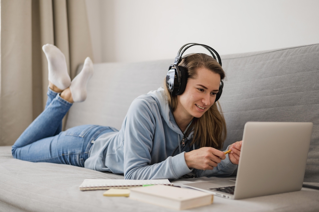 side-view-smiley-woman-couch-attending-online-class