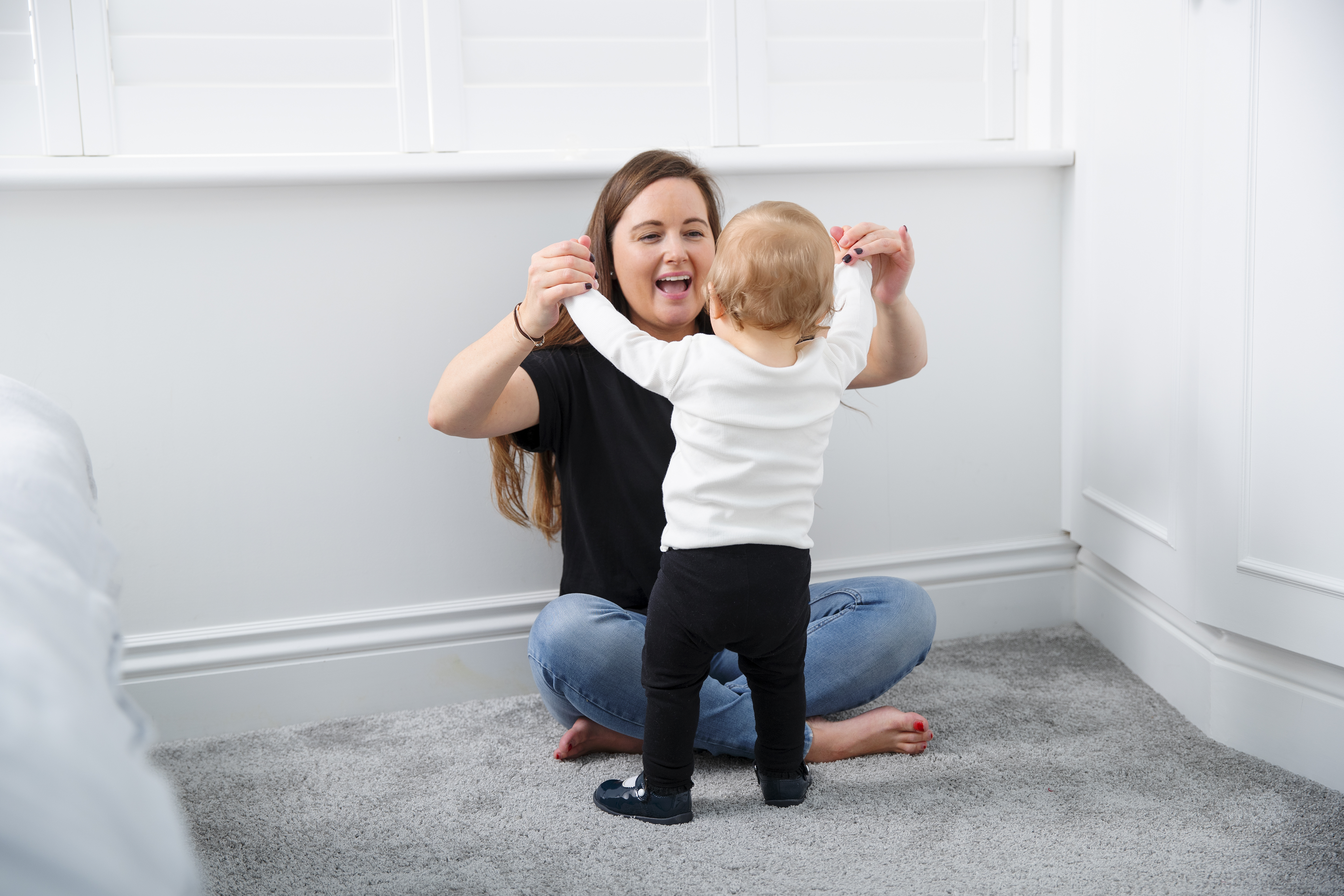 full-shot-mother-helping-kid-stand