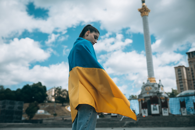 small-young-woman-covered-with-the-ukrainian-flag